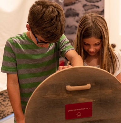 A boy and a girl interact with an exhibit at the Children of Gettysburg 1863